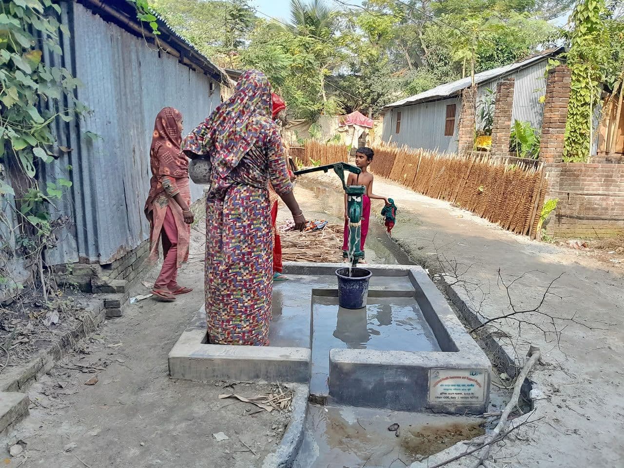 Woman using a village water pump